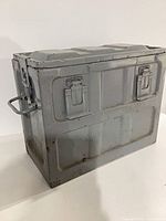 Full view of grey steel ammunition box with latches and handles