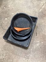 Rectangular pan with two round pans stacked inside and orange funnel on top