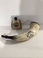 Large and small engraved powder horns front view