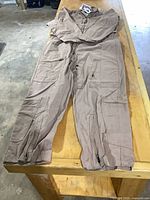 Full view of tan Propper coveralls laid flat on table