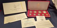 Outer sleeve, open display case with nine coins, certificate, leaflet