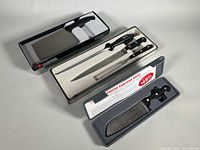 Entire lot showing boxed cleaver, Zwilling carving set tray, Slitzer Santoku case