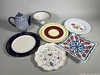 All seven porcelain and ceramic pieces laid out