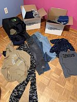 Overview of clothing lot on floor and in boxes