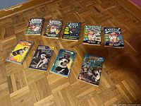 All nine paperback books laid out: five Captain Underpants titles on top row, four Wishbone titles on bottom row