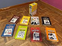 Eight books and yellow box sleeve spread on floor