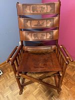 Full view of folding rocking chair showing wood frame, leather seat and slat back