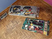 Both boxed train sets side by side on floor