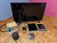 All items grouped: RCA TV, two iPads, Echo Dot with box, mouse, adapter, cables