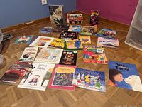 Full spread showing variety of approximately 25 children’s books laid on floor