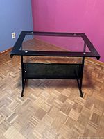 Front three-quarter view of desk showing glass top, frame and modesty panel