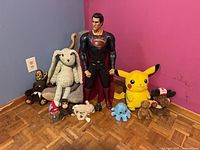 Group shot of Superman figure, Batman, and assorted plush animals