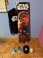 All six Star Wars items—hoodie, growth chart, two Hot Wheels cars, cap, Grogu figure—displayed together