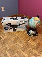 Boxed MiPosaur beside electronic globe