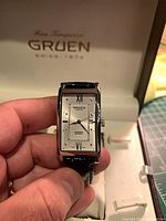 Front view showing dial, case shape, strap, box interior branding