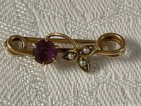 Front view of gold brooch showing amethyst and seed pearls