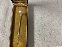 Full stick pin in open case showing pearl and shaft