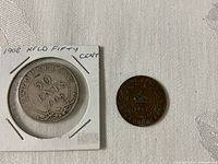 Both coins front side: 1908 50 cents in cardboard holder, 1917 1 cent loose