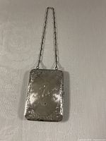 Closed purse front showing engraving and chain