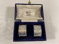 Pair of napkin rings in open fitted box showing interior lining