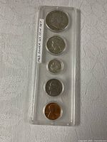 Front view of all five coins in vertical holder