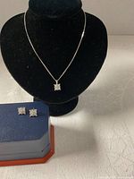 Necklace on display bust with earrings shown in box