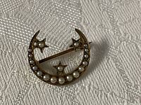 Front view showing seed pearl crescent and star design