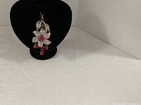 Pendant on black display bust showing full design