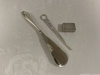Three sterling silver items: shoe horn, letter opener, pill box