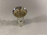 Side view of sterling jigger showing exterior finish and hourglass shape