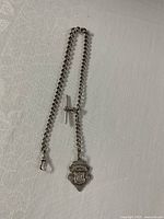 Full view of chain with T-bar, clasp and fob