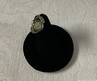 Front view of 10K gold ring displaying green center stone and accents