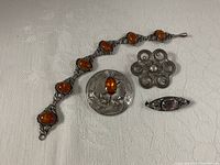 All four sterling silver jewellery pieces on fabric background