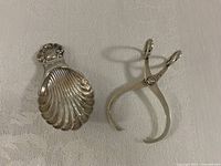 Tea caddy scoop and sugar tong side by side