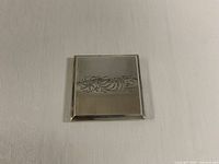 Front of sterling silver compact showing floral engraving