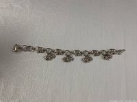 Full view of sterling silver elephant charm bracelet laid flat