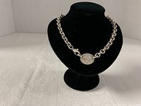 Necklace displayed on bust showing chain style and tag inscription