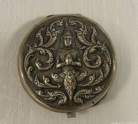 Front view showing repousse deity and scrollwork