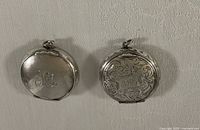 Front view of both sterling compacts showing monograms and engraving