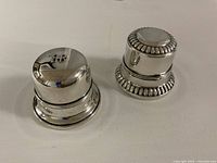 Two sterling silver Birks ring boxes closed, showing exterior designs