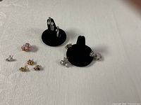 All earrings arranged on cloth with two black display stands