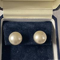 Front view of both pearl earrings in box