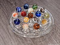 All marbles displayed on glass stand from left angle