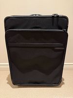 Front view of black Briggs & Riley suitcase upright