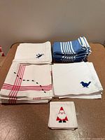 All five napkin sets stacked: bird, crab, ant, striped, Santa