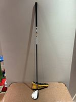 Full view of TaylorMade RBZ Stage 2 7-wood and headcover leaning against wall