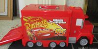 Closed red Mack truck with Rust-eze Lightning McQueen 95 graphics