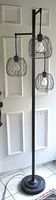 Full view of 72" black tree floor lamp showing three cage shades and round base