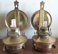 Front view of both brass wall-mount oil lamps with reflectors