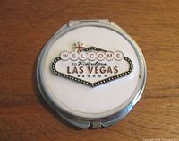 Closed compact showing Las Vegas sign on white lid